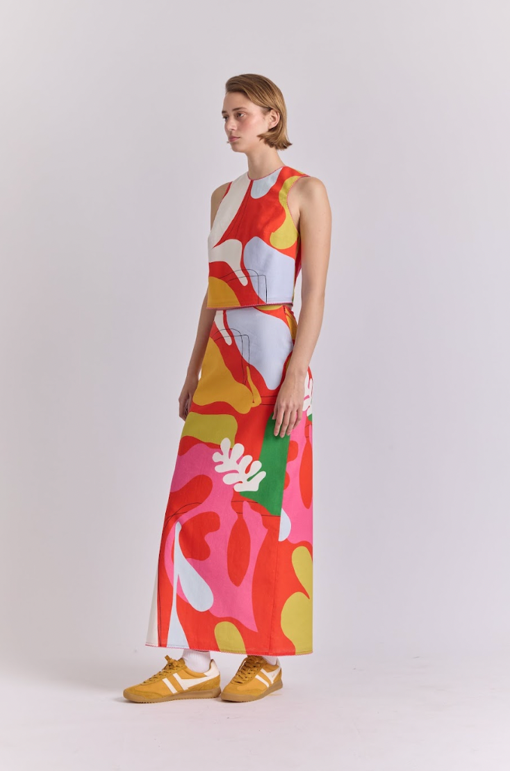Polen skirt worn front, straight midi with abstract red, pink, yellow, and green graphic print