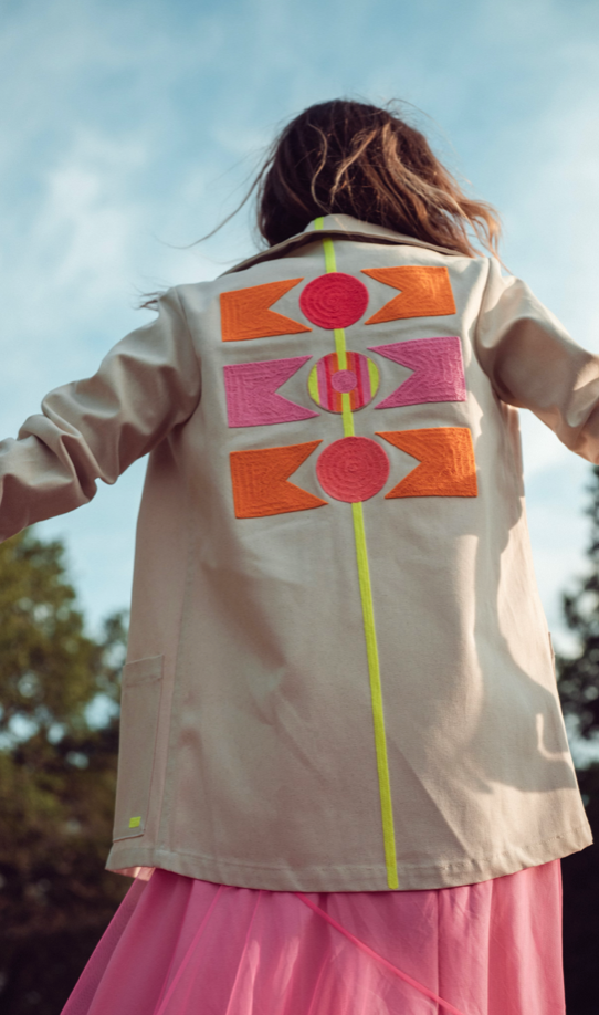Light beige jacket, close back view, geometric patchwork print with neon green line