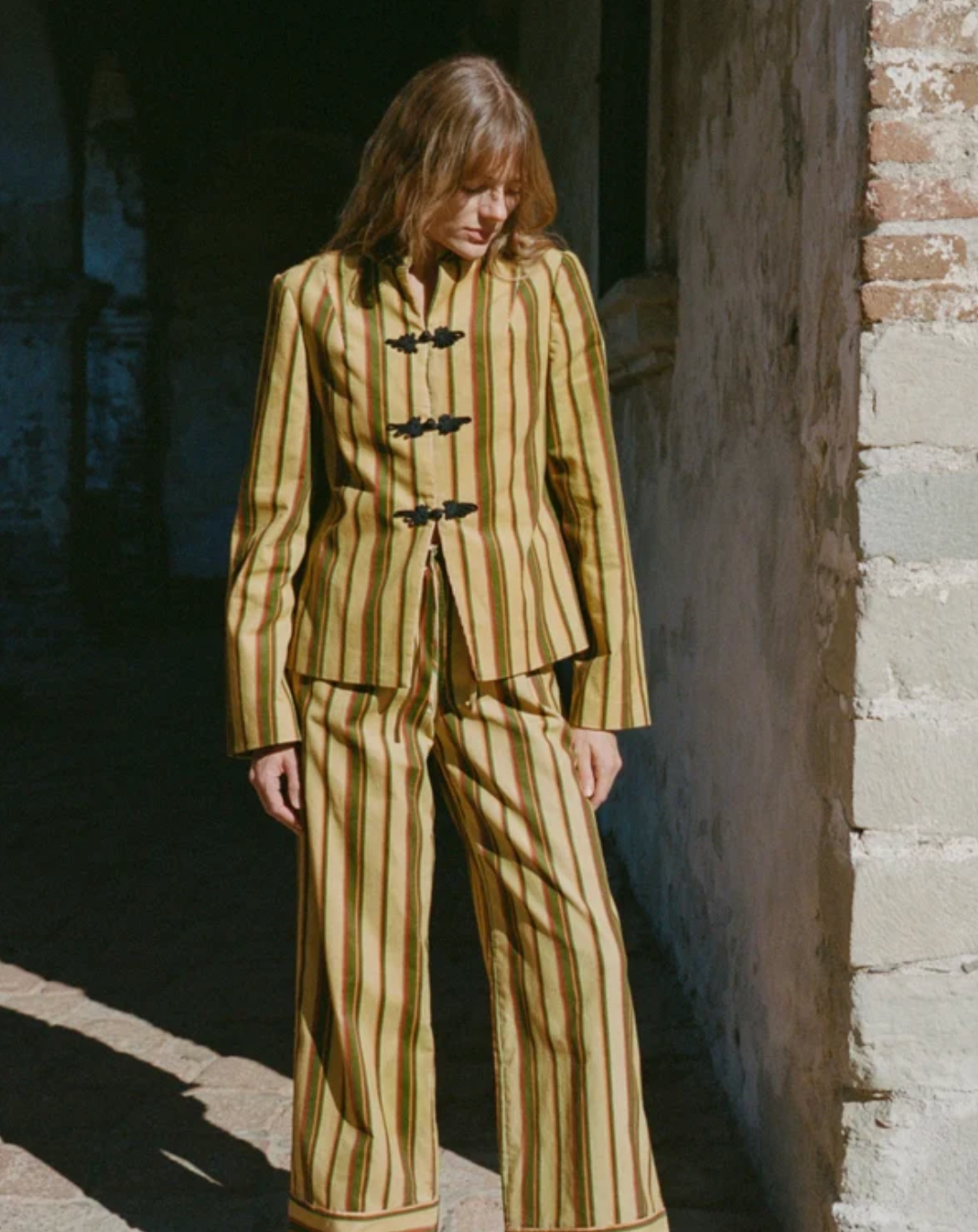 Striped jacket with dark toggle front and long sleeves, standing collar