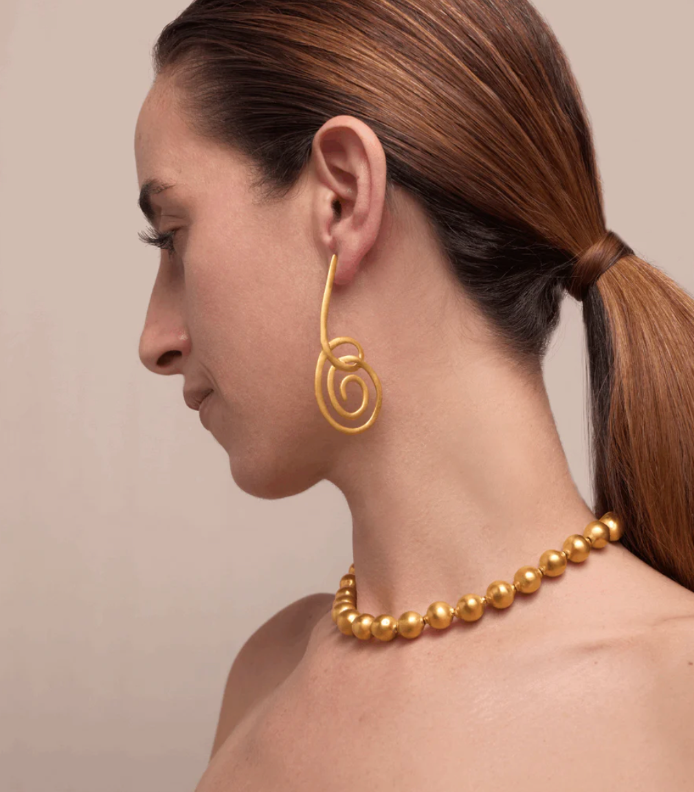 Unpuri gold-tone spiral drop earrings worn, dangling swirl motif