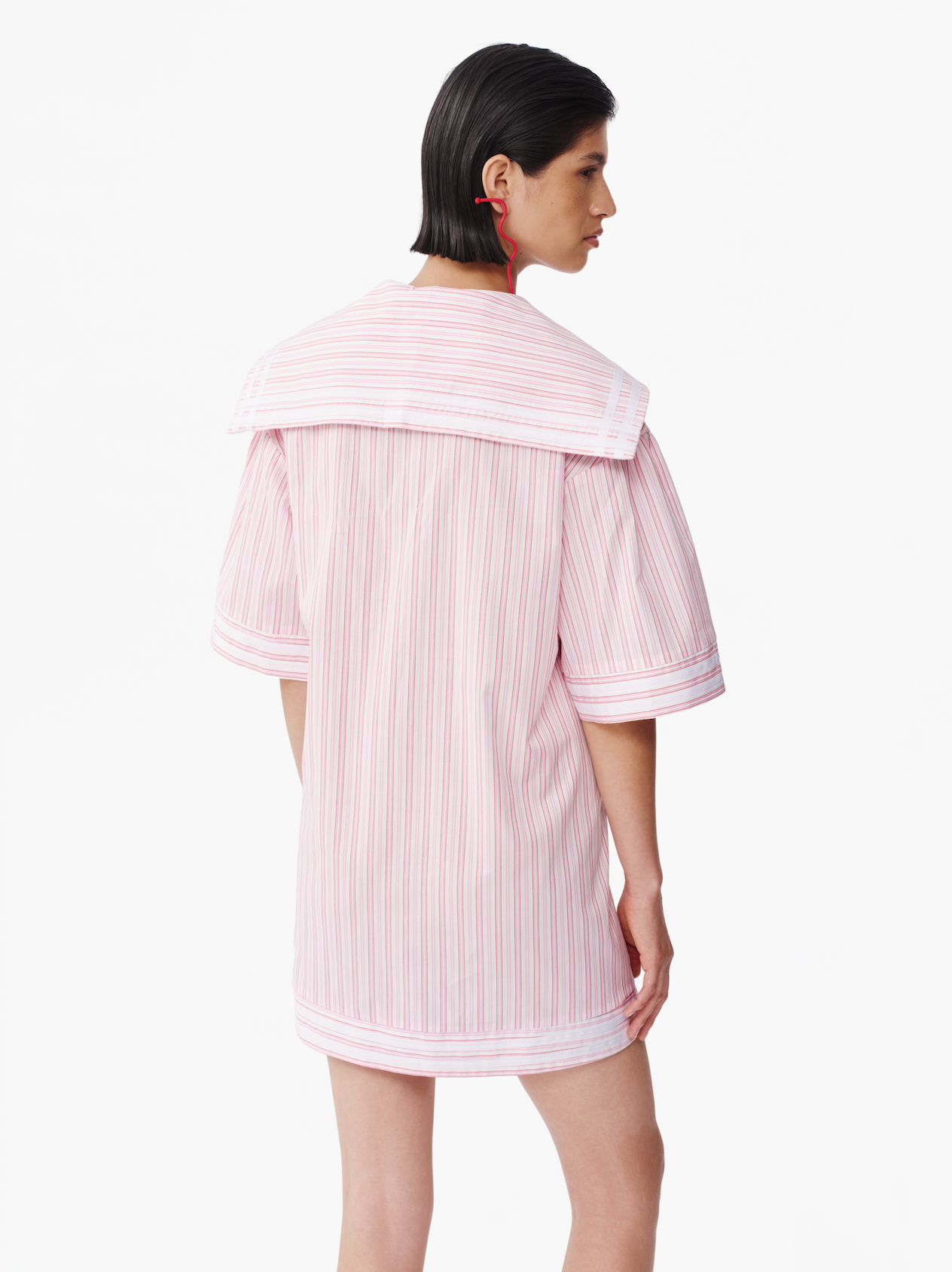 Back view of striped hooded mini dress in pink vertical stripes with banded sleeve hem