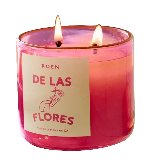 Roen scented candle, clear jar with pink-red wax and DE LAS FLORES label, lit