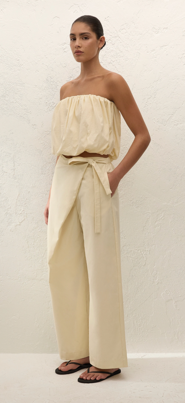 Cream wide-leg trousers with tied high waist and side drape detail