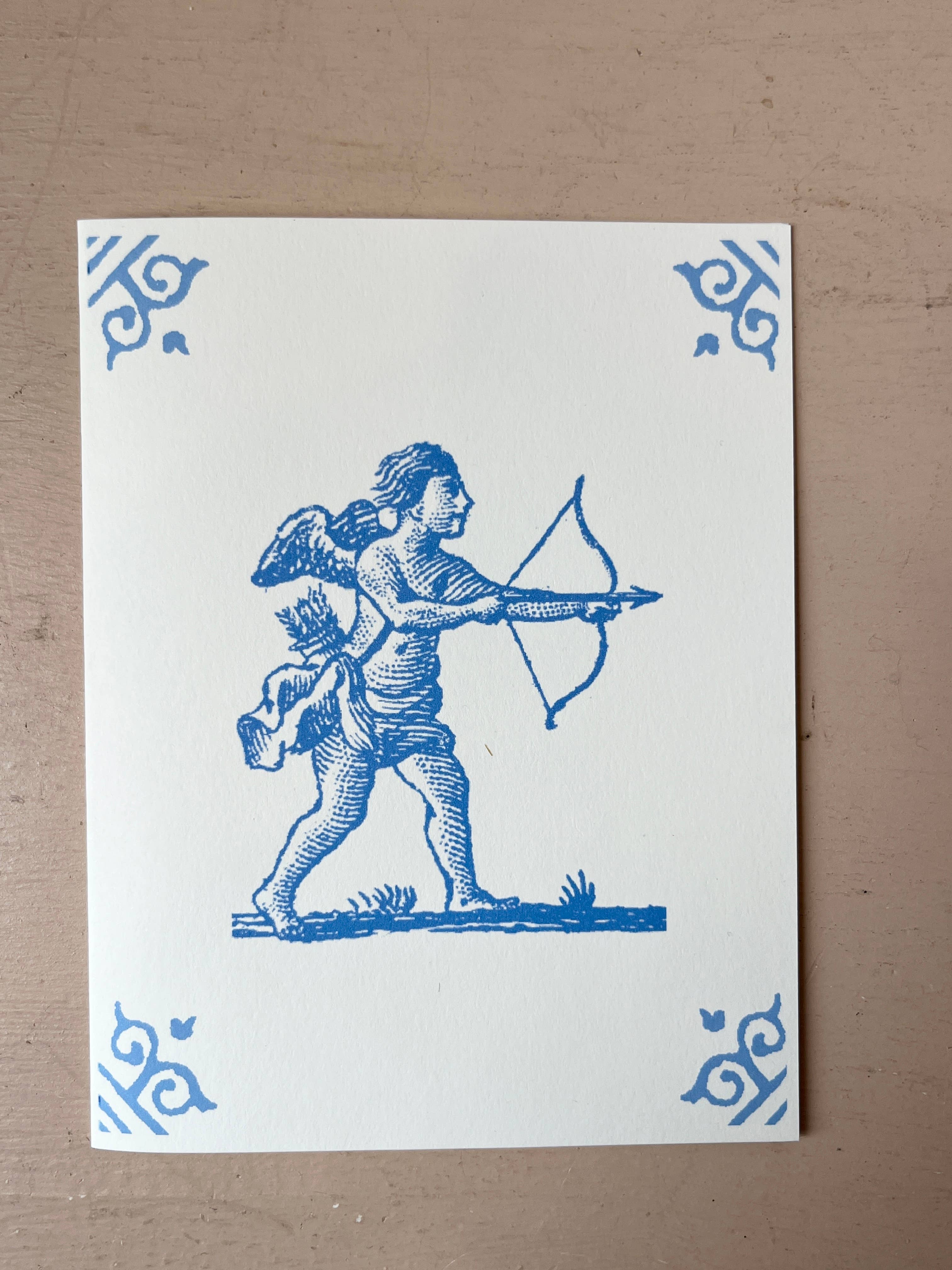 White card with blue illustration of an archer dog holding a bow and arrow, corner motifs
