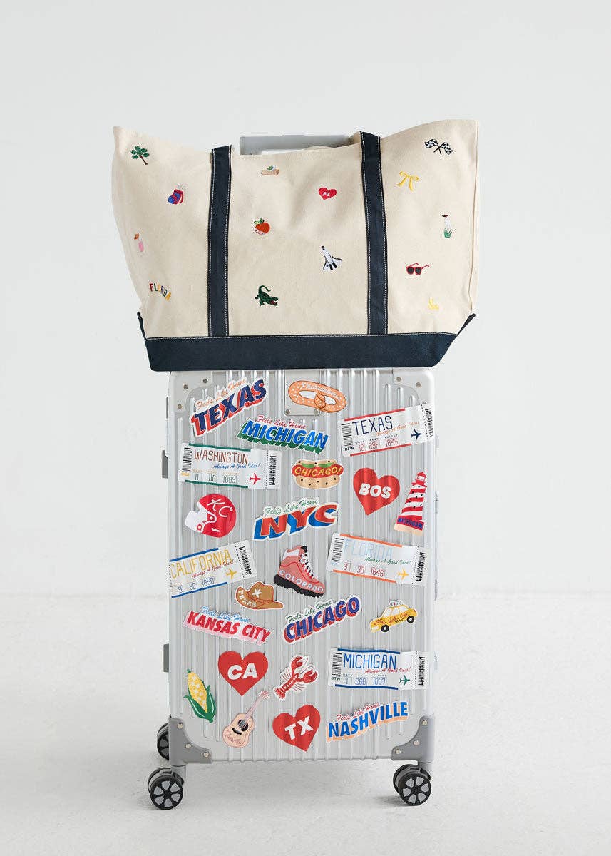 Canvas tote bag with navy handles and side panels, colorful Florida icons pattern