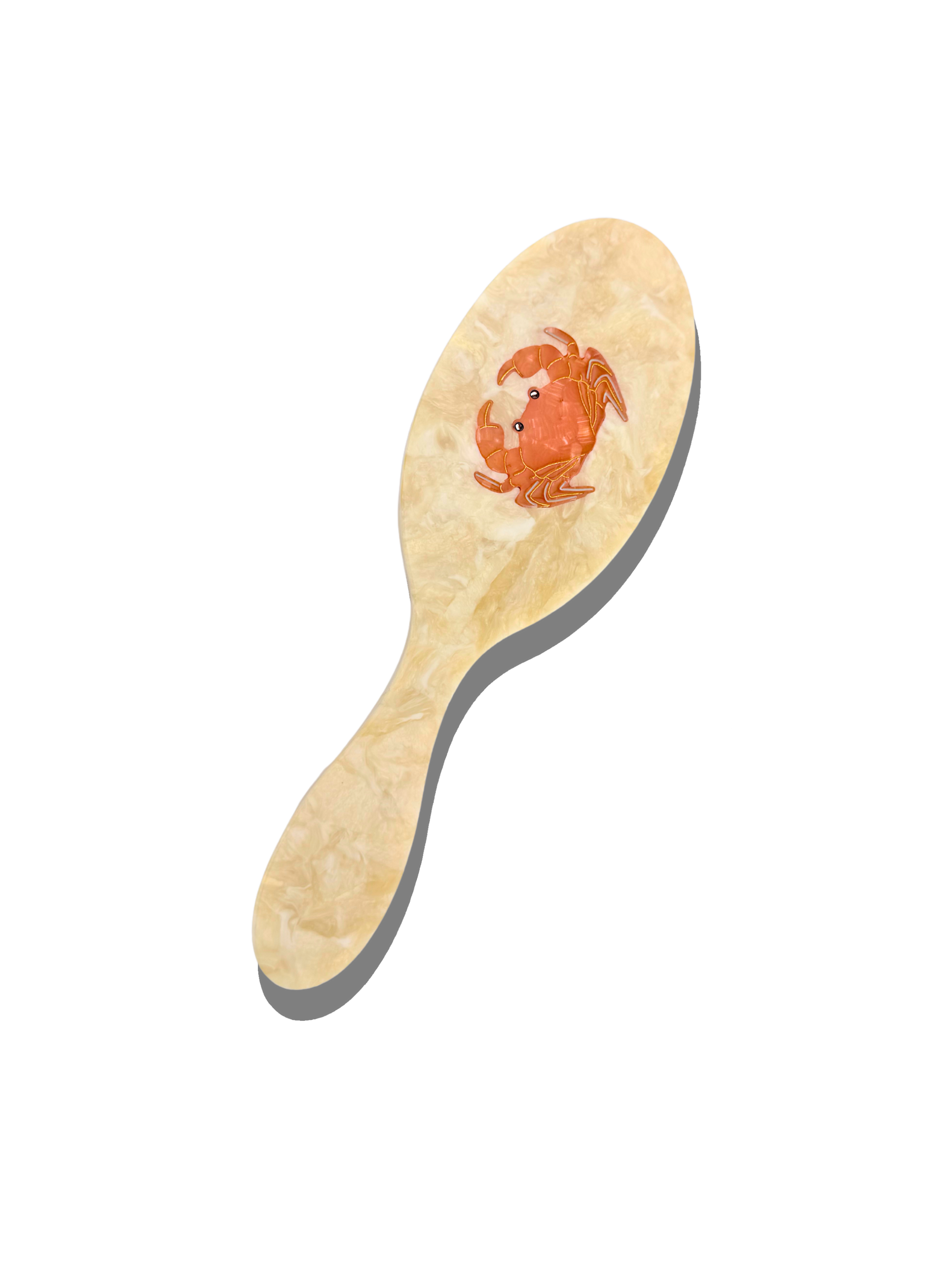 Crab hairbrush with pale wood-look handle and raised crab design on brush pad