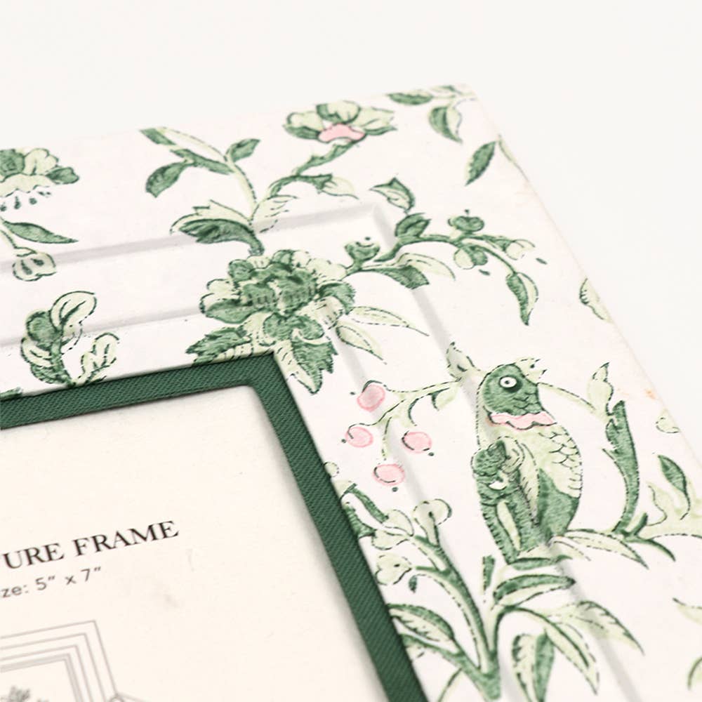 Wall picture frame corner with dark green mat and floral bird block print.