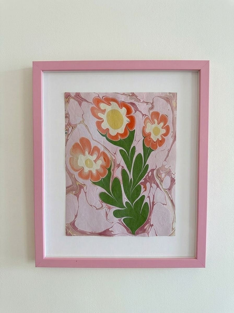 Framed flower painting with orange and red blooms on light marbled background