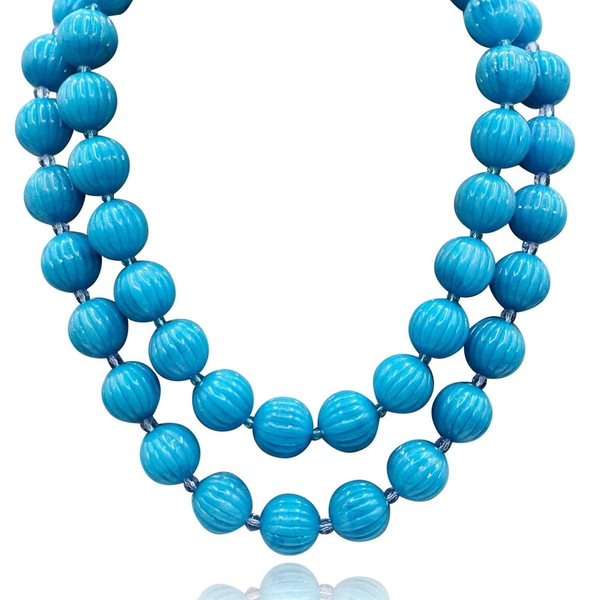 Turquoise melon bead necklace featuring round carved beads along the strand