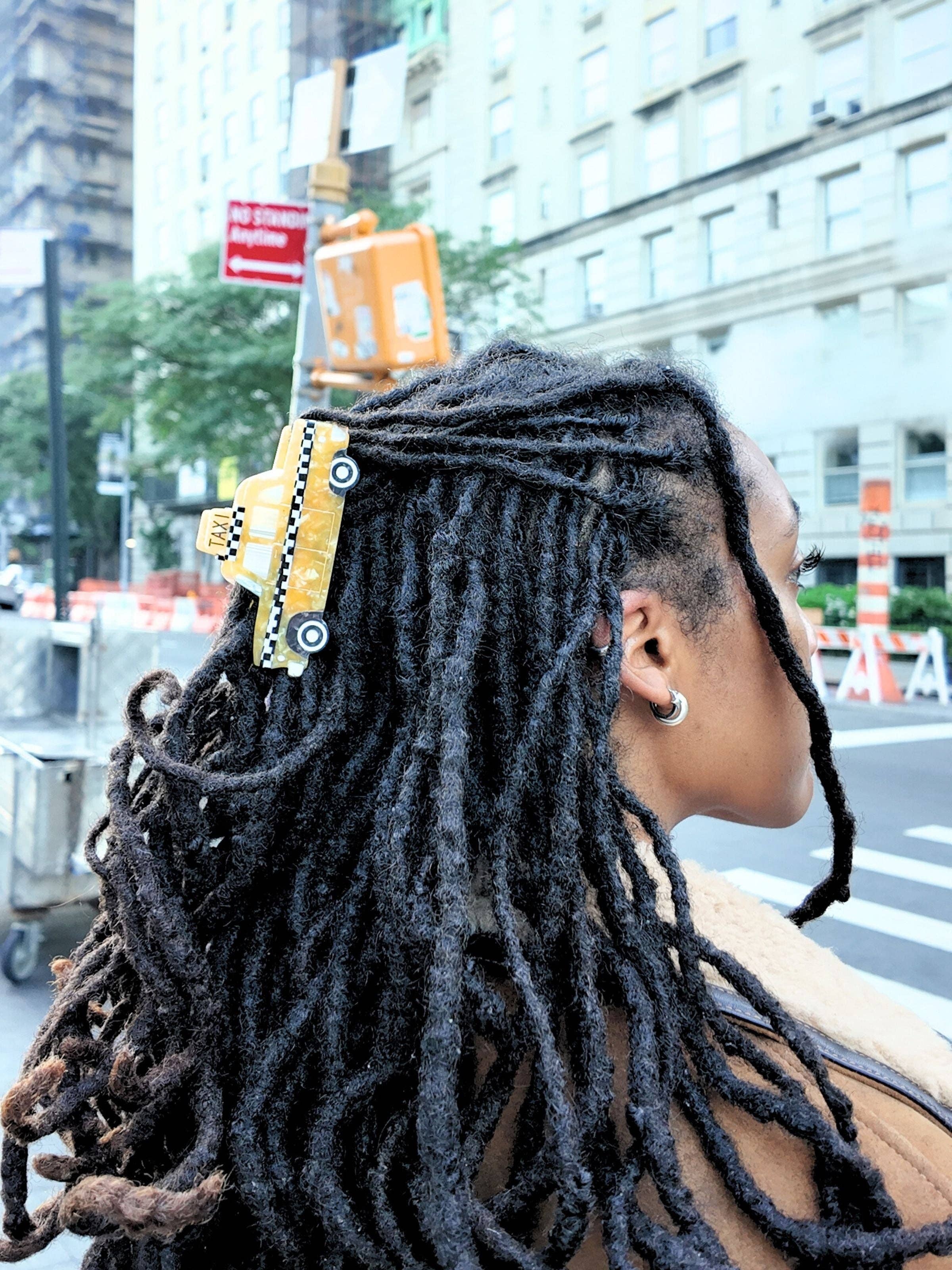 Taxi cab claw hair clip, yellow with checkered stripe, on dark dreadlocks