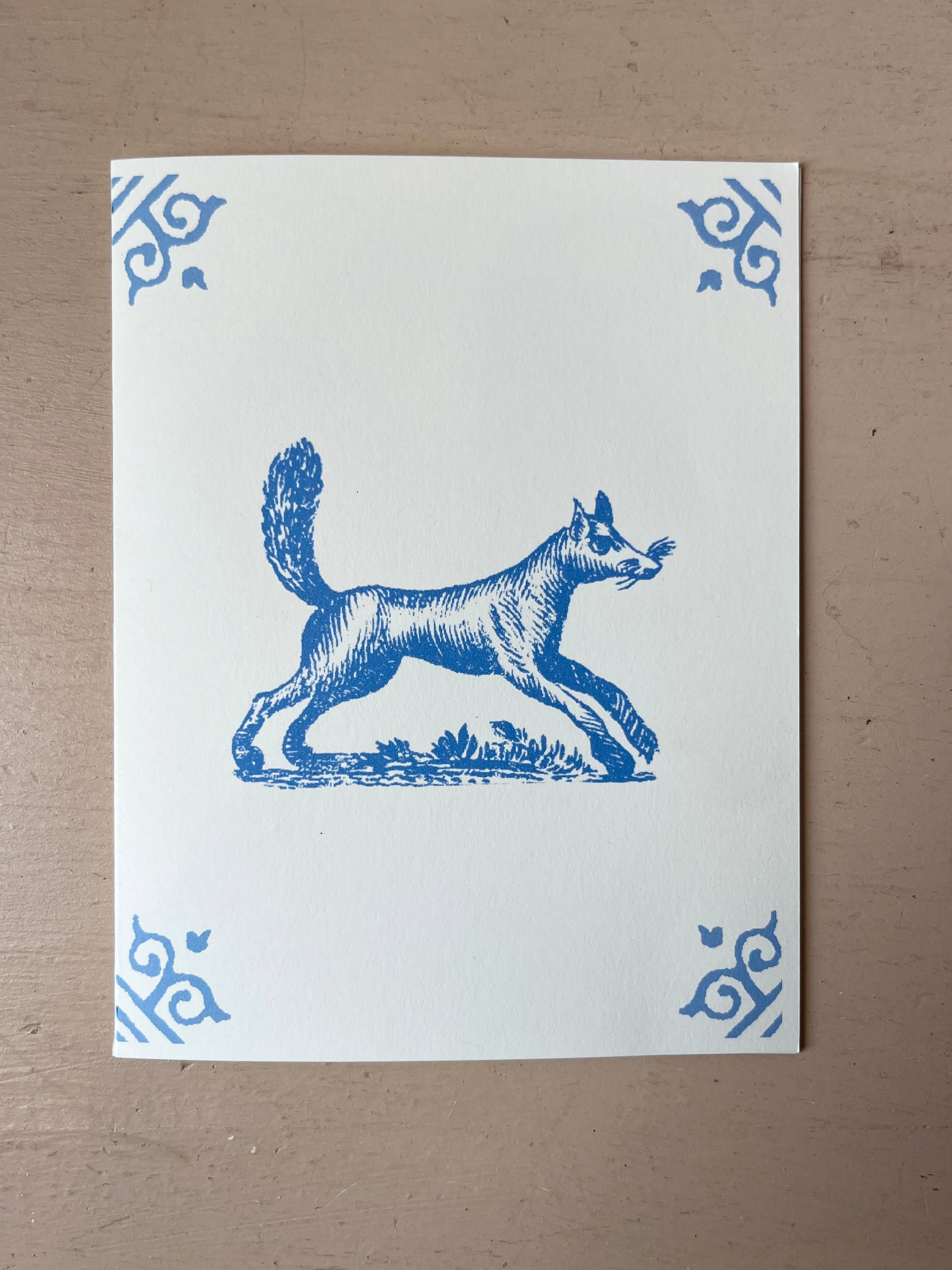 White card with blue illustration of a standing dog in profile, ornate corner motifs