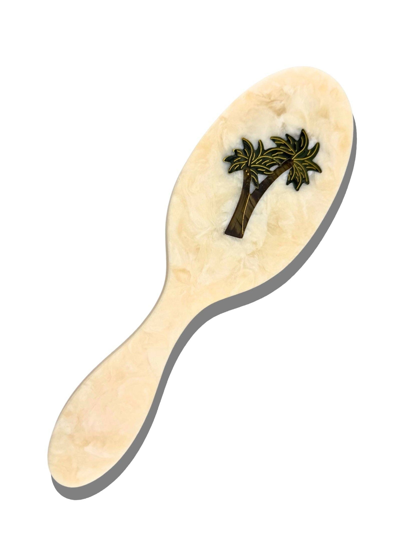 Beige paddle hairbrush with dark green palm tree decal