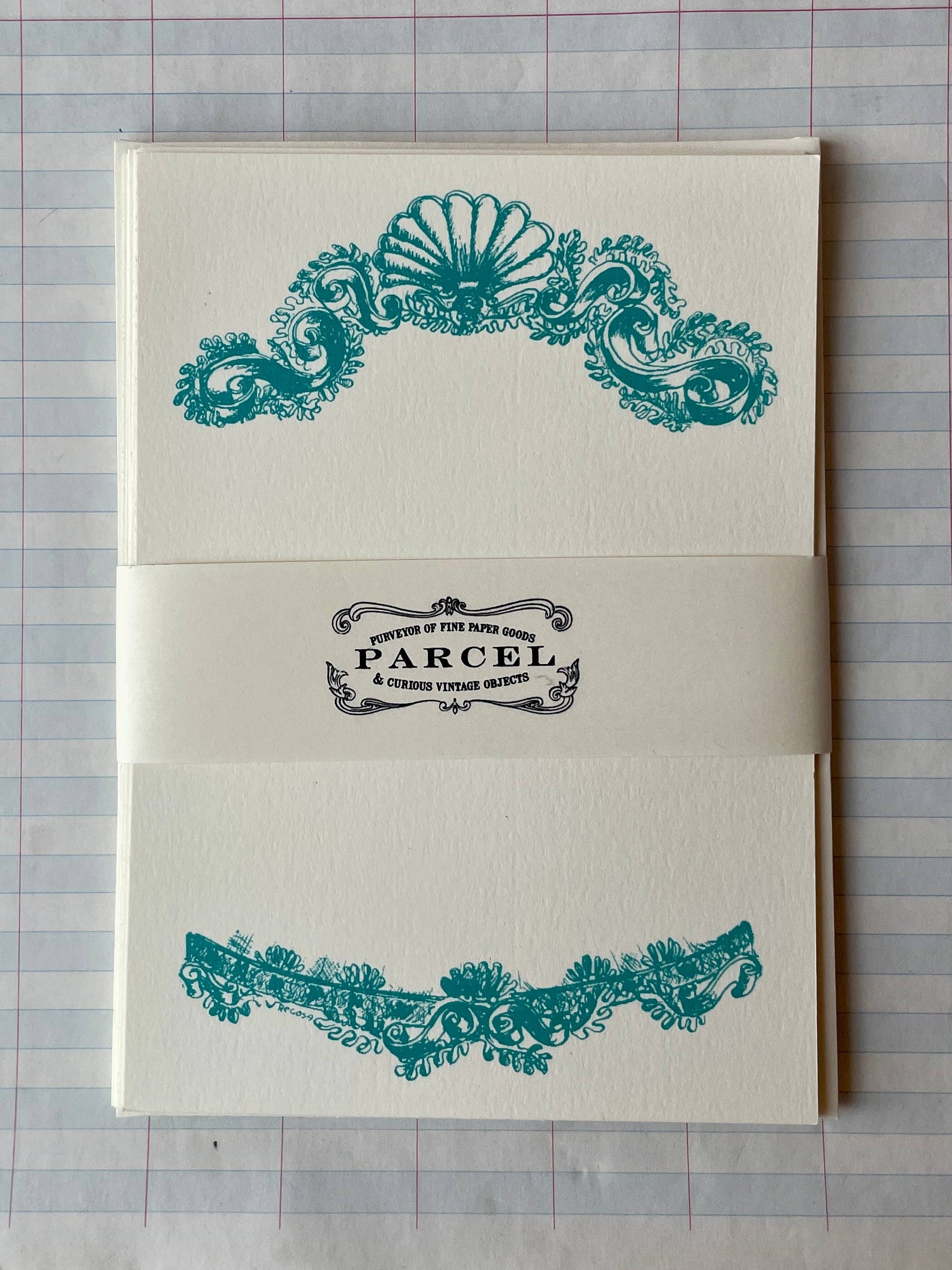 Shell banner with teal ornate shell scroll design and PARCEL label on cream paper