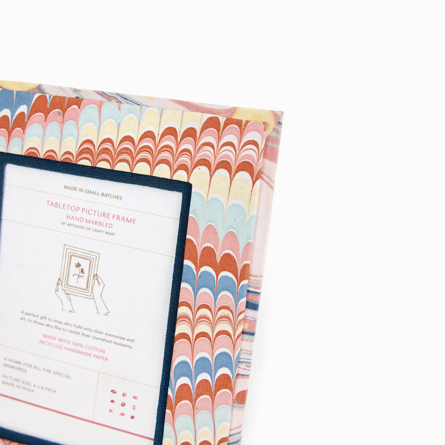 Hand marbled tabletop picture frame close-up of white label panel and marbled paper