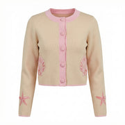 Beige cardigan with pink button placket and shell prints at cuffs