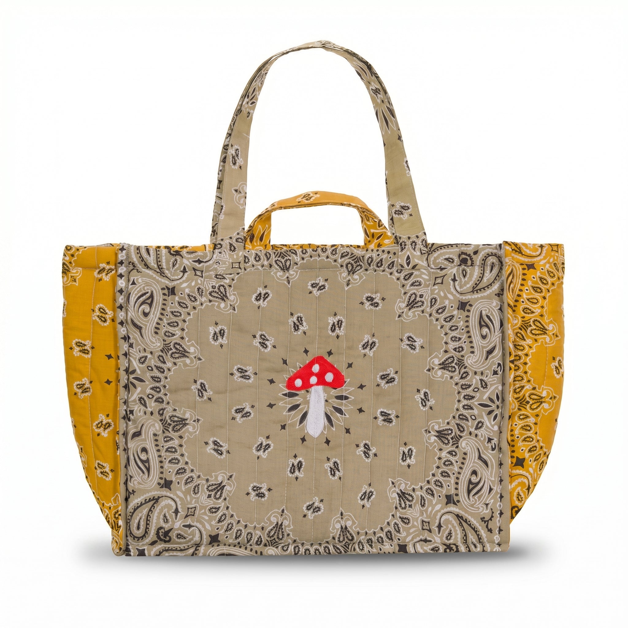 Quilted cabas tote with paisley patchwork panels, mustard sides, red charm and top handle