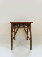 Wicker side table with woven top and four tapered dark-brown legs