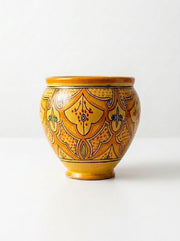 Orange ceramic vase with ornate gold and dark pattern, rounded shape